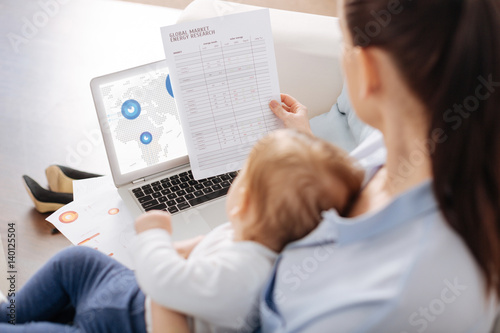 Clever ambitious gentle mother studying some data