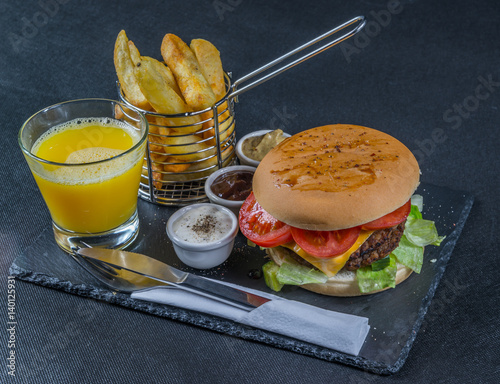 Fotografía right side view on a flame grilled double stack cheeseburger, lettuce, tomato, w