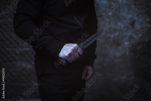 Classic street villain holding up a knife