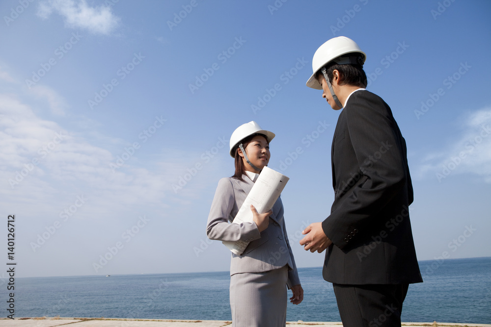 Engineers discussing with each other at construction site Engineers discussing with each other at construction site
