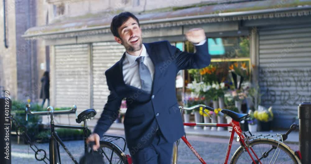 A businessman dancing in the square and is glad to have received a promotion or winning a bet. Concept: finance, business, elation, victory, wager, career, dance A businessman dancing in the square and is glad to have received a promotion or winning a bet. Concept: finance, business, elation, victory, wager, career, dance