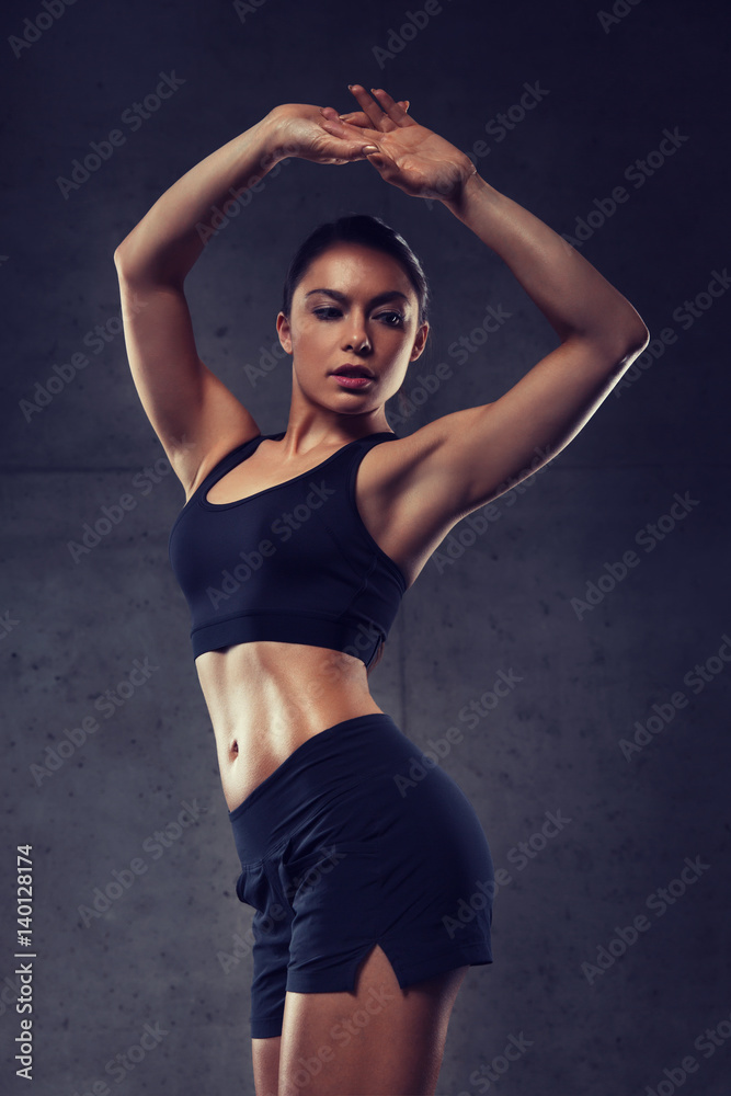 young woman posing and showing muscles in gym young woman posing and showing muscles in gym