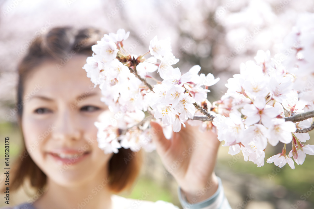 Young woman holding cherry tree branch Young woman holding cherry tree branch