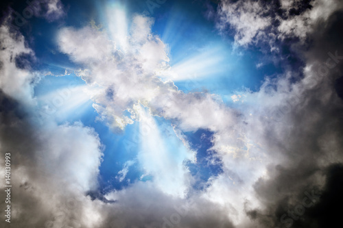 Light or sun rays bursting from the clouds in shape of a cross