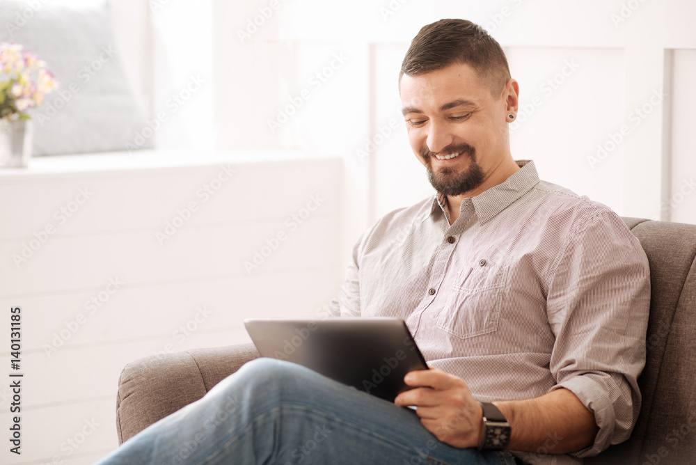 Delighted self employed businessman using a tablet Delighted self employed businessman using a tablet