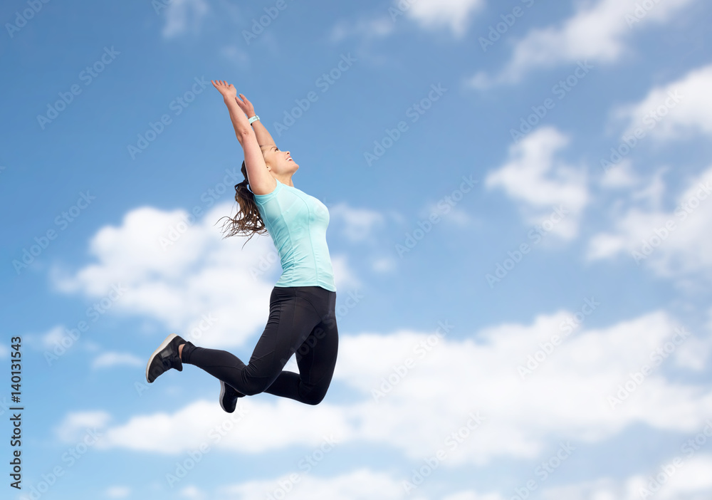 happy sporty young woman jumping in blue sky happy sporty young woman jumping in blue sky