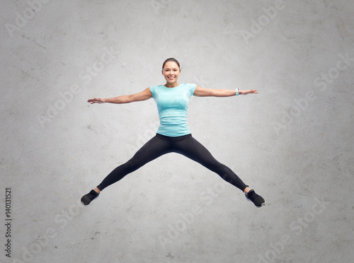 happy smiling sporty young woman jumping in air