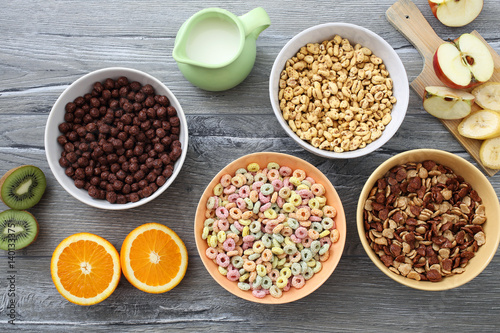 prima colazione con cereali colorati e frutta su tavolo di cucina grigio