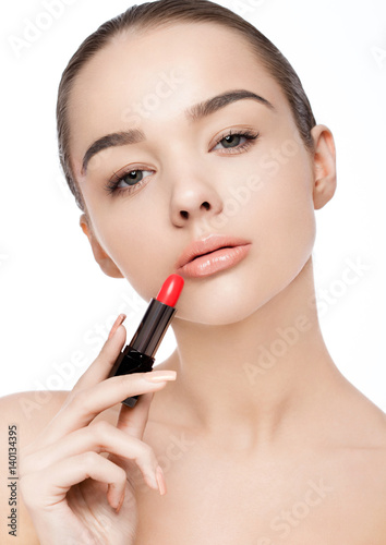 Beautiful model girl holding lipstick tube makeup