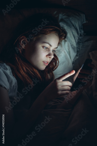 woman with phone in dark room night 
