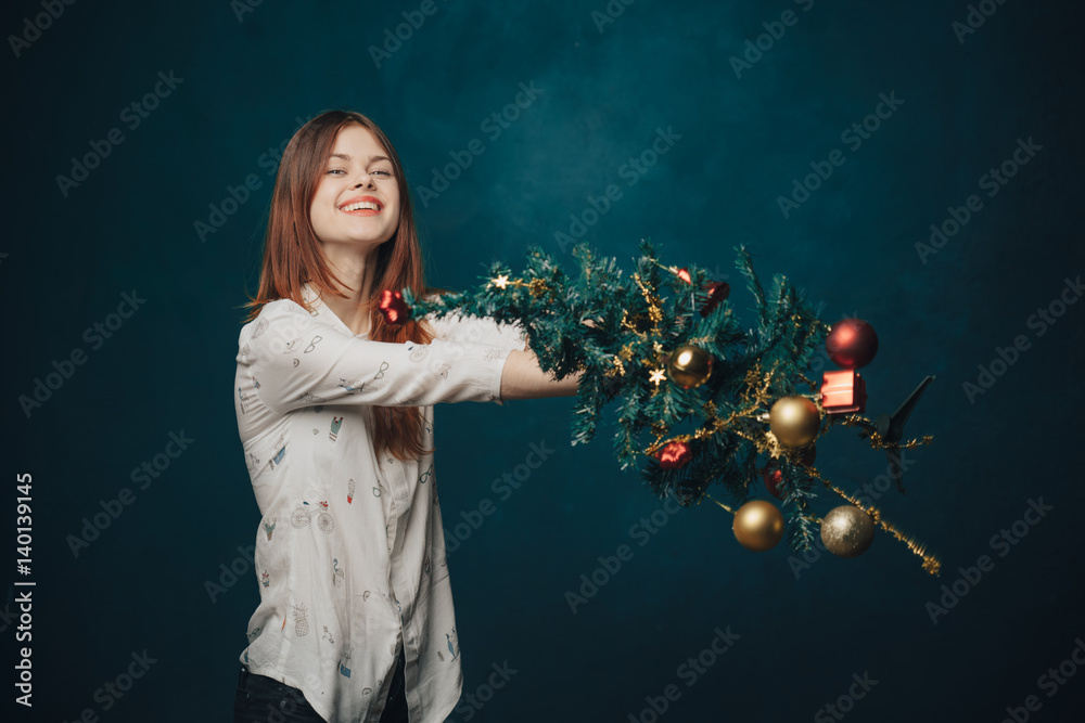 woman smiling with Christmas tree in hands
woman smiling with Christmas tree in hands