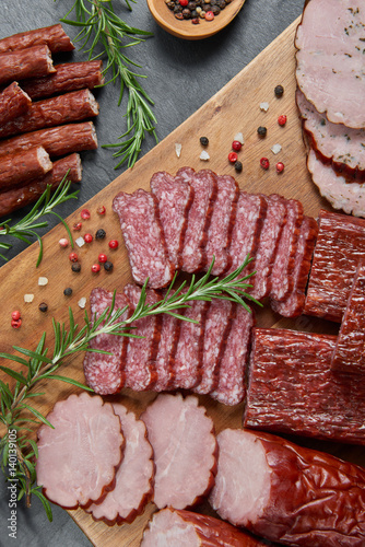 Set of cold cuts on a wooden board. Mix of sausages