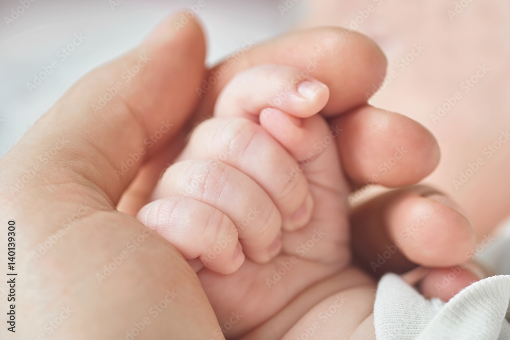 A parent holding the hand of a newborn baby A parent holding the hand of a newborn baby