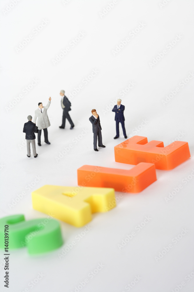 Group of businessmen figurines standing next to the word Sale Group of businessmen figurines standing next to the word Sale