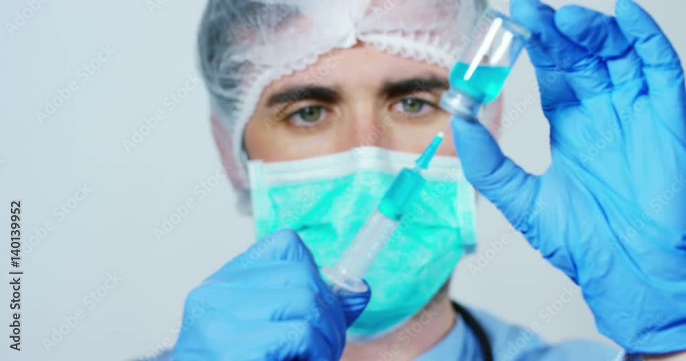In a laboratory, a scientist with a pipette analyzes a colored liquid to extract the DNA and molecules in the test tubes. Concept: research, biochemistry, nature, pharmaceutical medicine