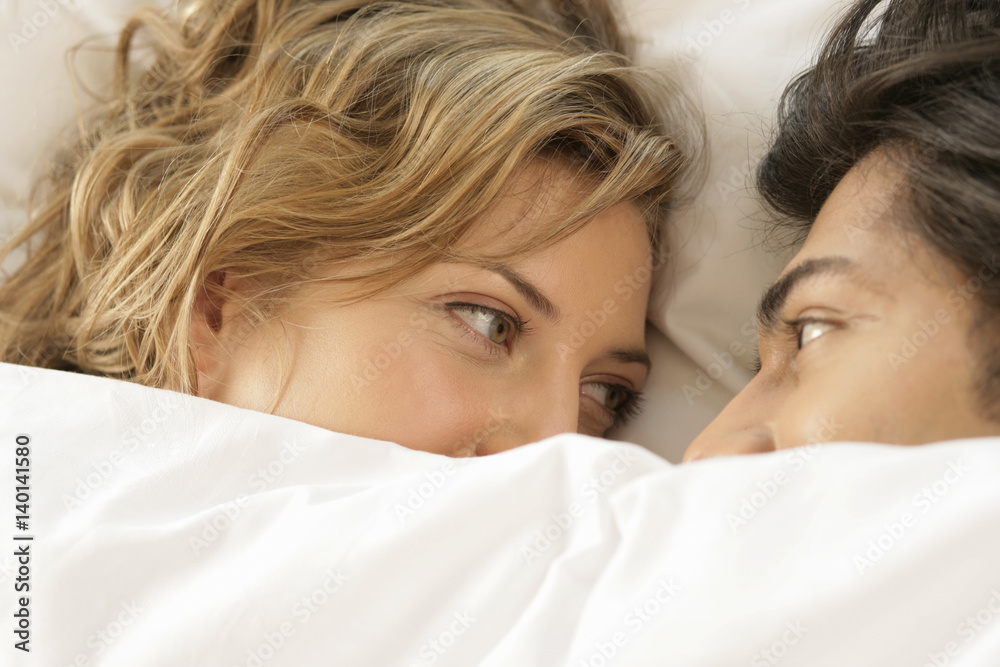 Young couple lying in bed, face to face Young couple lying in bed, face to face