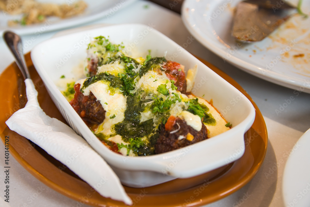 homemade meatballs baked with tomato, cream and pesto sauce