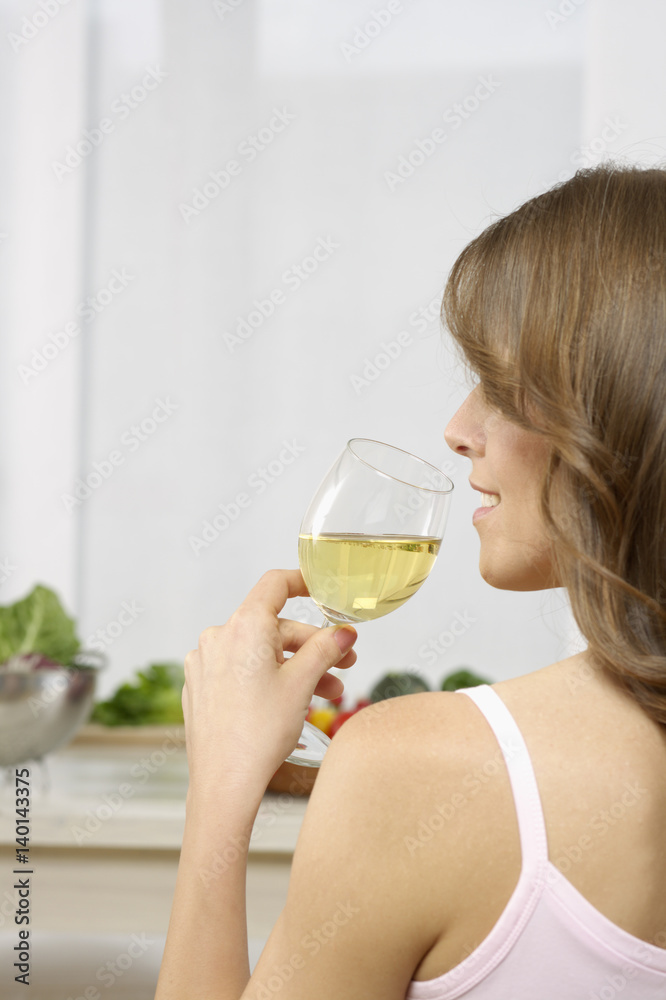 Mid adult woman drinking a glass of white wine Mid adult woman drinking a glass of white wine