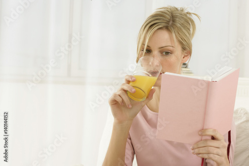 Fotografija Woman reading a book, drinking juice