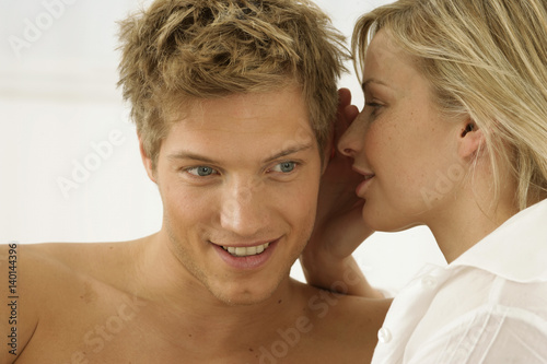 Woman whispering in man's ear