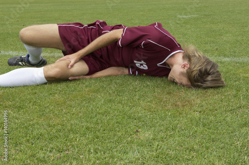Injured kicker lying on soccer field