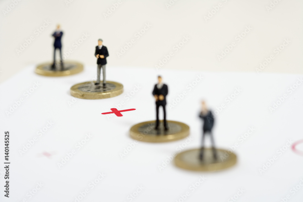 Plus sign between businessmen figurines standing on one Euro coins Plus sign between businessmen figurines standing on one Euro coins