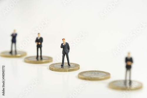 Businessmen figurines standing on one Euro coins