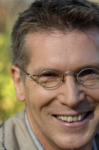 Man smiling with steel rimmed spectacles, Portrait