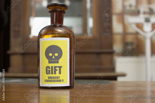 A brown glass bottle with poison sign
