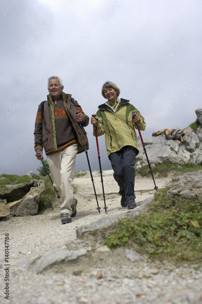 Senior adult couple hiking in the mountains, low angle view
