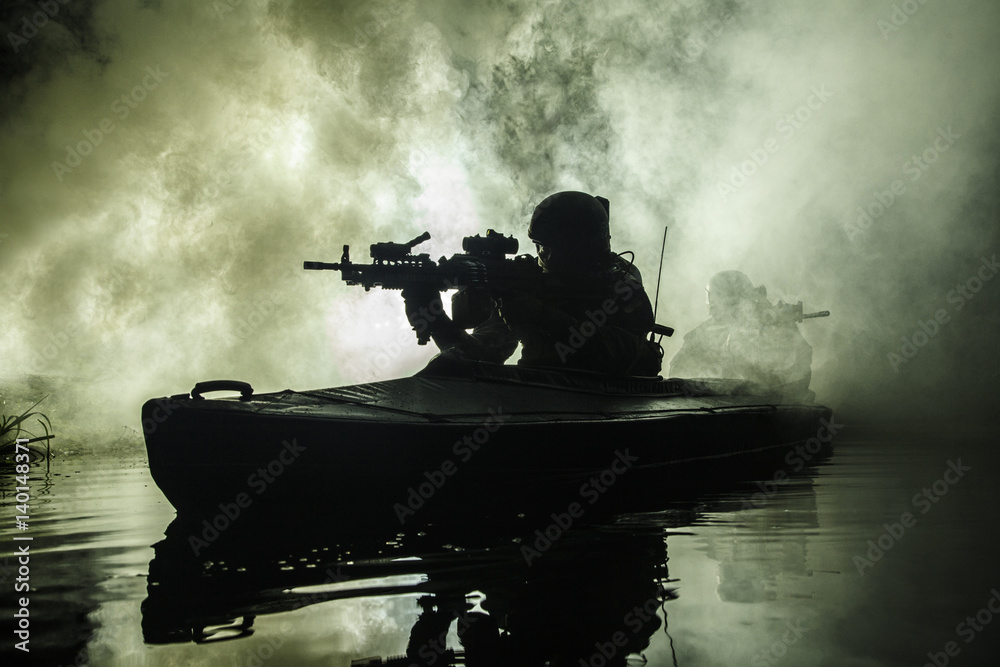 Backlit silhouette of special forces marine operators in military kayak on fire explosion background. Battle operation, bombs exploding