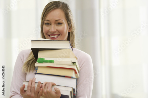 A woman is carrying some books