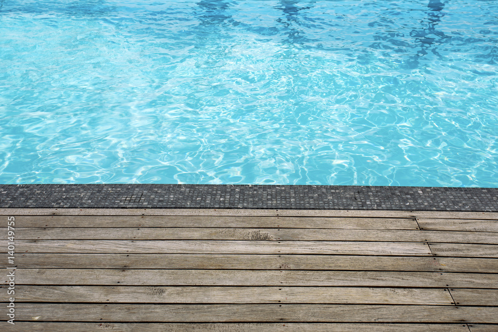 Blue swimming pool summer vacation and wooden deck