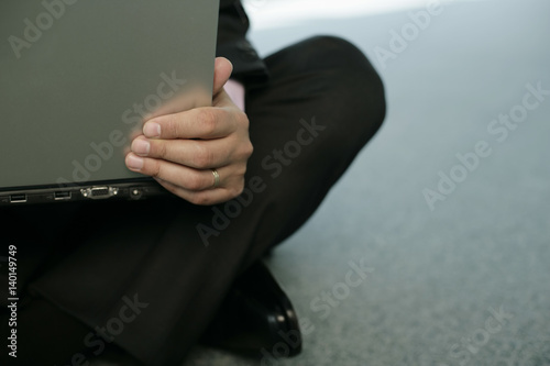 Businessman sitting on floor and using a laptop