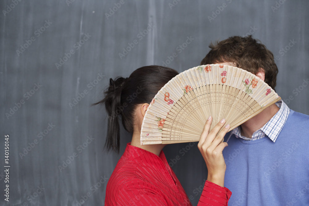 Φωτογραφία Young man and Japanese woman flirting behind a wooden fan