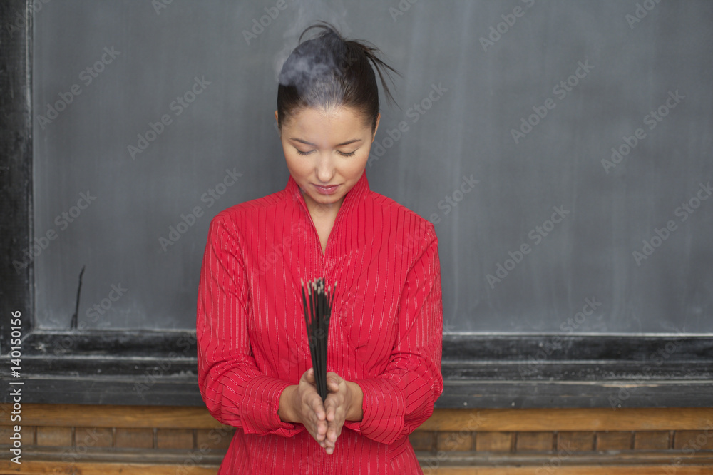 Φωτογραφία Asian woman is holding chopsticks in front of a blackboard