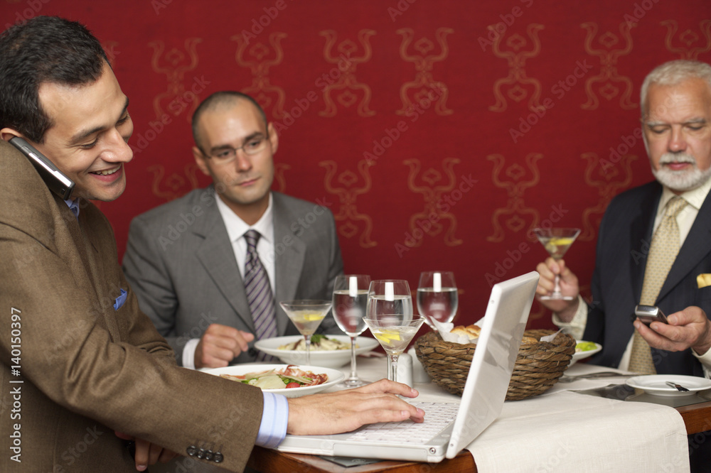 Three businessmen having a business lunch Three businessmen having a business lunch