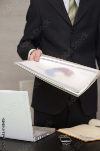 Businessman handing over documents in his office