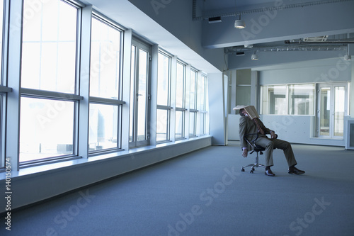 Exhausted businessman sitting in an empty office