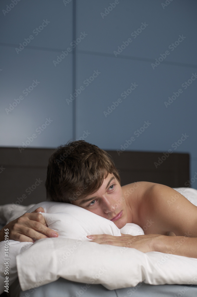 Young naked man in bed, close-up, portrait Young naked man in bed, close-up, portrait