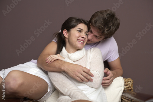 Fotografie Young heterosexual couple cuddling on a bass chair