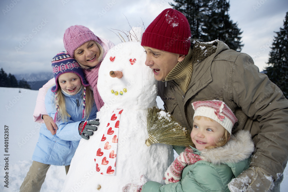 Family posing with snowman Family posing with snowman