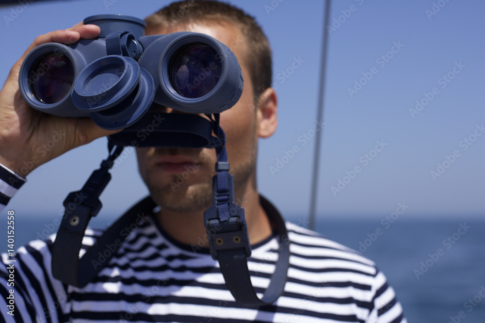 Obraz premium Man looking through a spyglass