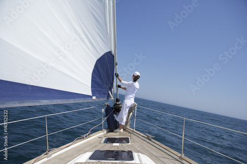 Woman standing on the bow of a sailboat © Gudrun