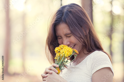 Young asian woman with flower in the park in vintage color tone