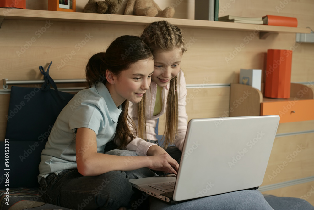 Two friends using a laptop Two friends using a laptop