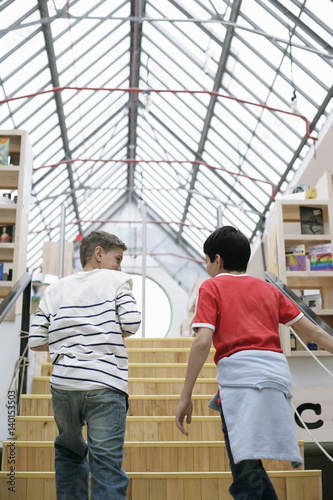 Two boys ascending staircase in a library, fully_released © Gudrun