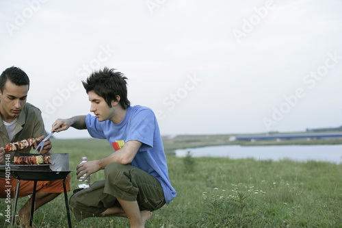 Two young men grilling
