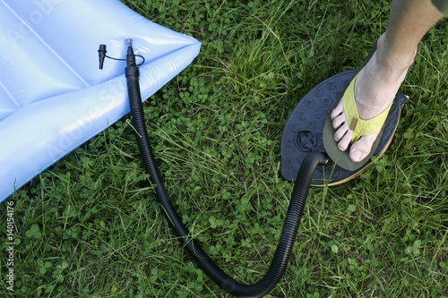 Man pumping up a blue airbed