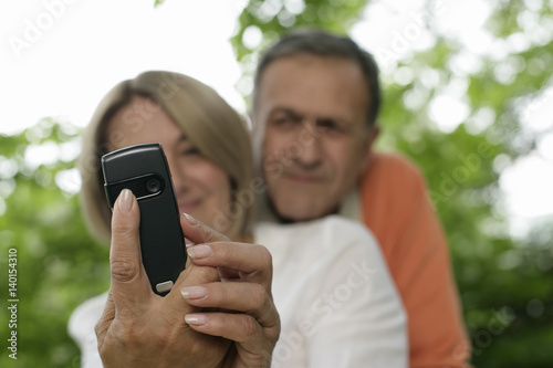 Mature couple taking a photo by a mobile phone